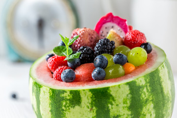 Tasty fruits salad in watermelon with berry fruits
