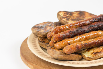 Baked potatoes with grilled bbq sausages on the plate