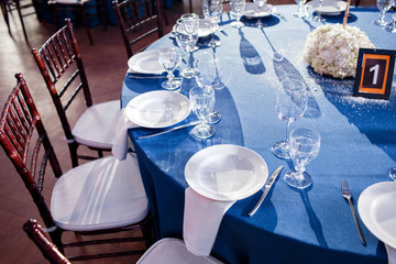 Wedding. Banquet. The chairs and round table for guests, served with cutlery and crockery and...