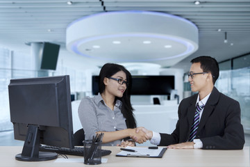 Woman and her colleague shaking hands