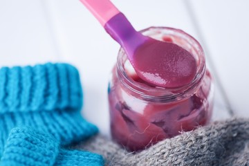 Jar baby fruit puree on wooden background