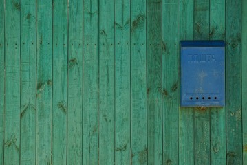 Почтовый ящик на зелёном заборе