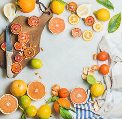 Natural fresh citrus fruits slices on wooden rustic cutting board over grey marble table...