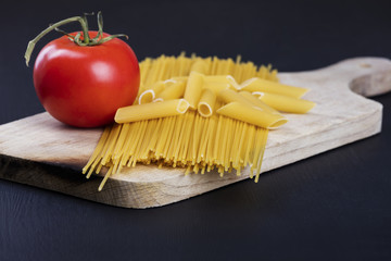 Uncooked pasta and red fresh tomato