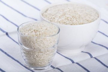 Glass and bowl of white raw rice