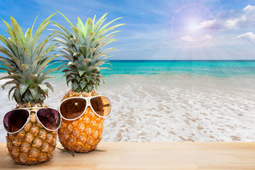 pineapple with sunglasses on wood,concept summer background.