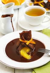 Fototapeta na wymiar Chocolate pancakes with orange and chocolate sauce