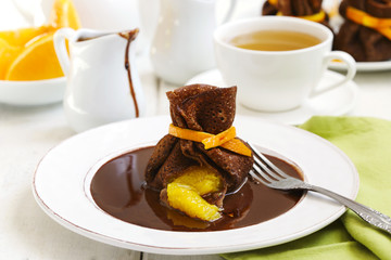 Chocolate pancakes with orange and chocolate sauce