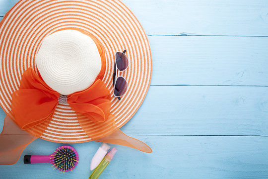 Beautiful lady hat with sunglasses and sunscreen on wood background,for summer season background.