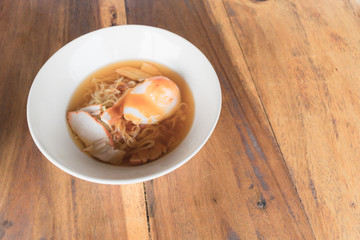 Close up thai pork noodle with big egg.
