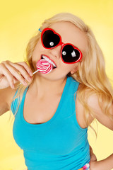 Funny blonde woman bites lillipop