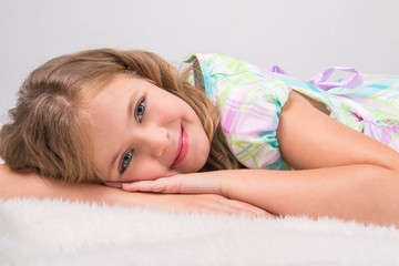 beautiful girl lying on gray fur