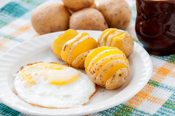 Baked potatoes and yellow eggs on a white plate