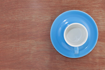 Empty blue coffee cup on wood.