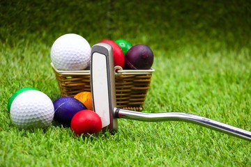 Golf ball and easter eggs on green grass