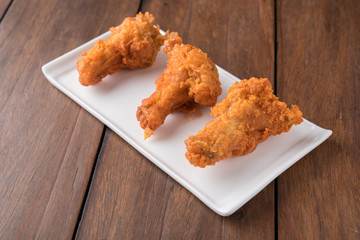 Fried chicken on the wooden background.
