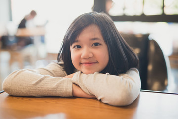 portrait of beautiful Adsian girl smiling in a coffee shop