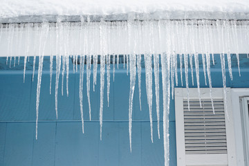 house roof with icicle hanging in winter