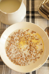 Breakfast on checked table-cloth boiled buckwheat with butter vertical
