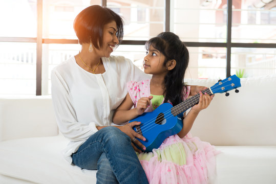 Indian Mother And Daughter Playing Ukulele