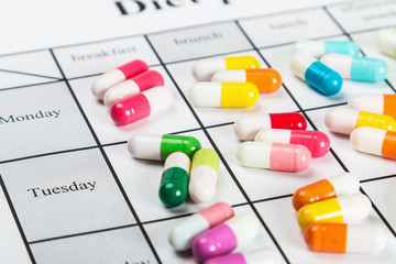 pills of different colors on a calendar medication