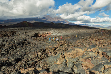 Tourists hiking on lava field eruption Tolbachik Volcano on Kamchatka Peninsula, Klyuchevskaya Group of Volcanoes.
