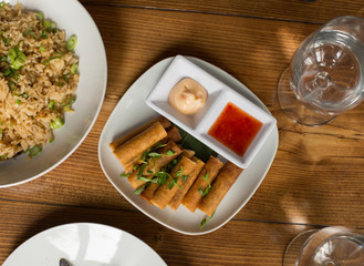 Lumpia Spring Rolls on Wooden Table in Restaurant