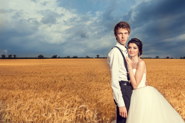 Naklejka na ściany i meble Beautiful just married couple in wheat field