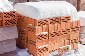 Pallets of the perforated red bricks on an outdoor warehouse
