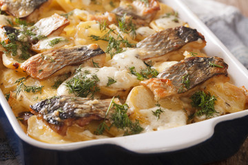 Finnish Food: Casserole with potatoes and herring close up in baking dish. horizontal