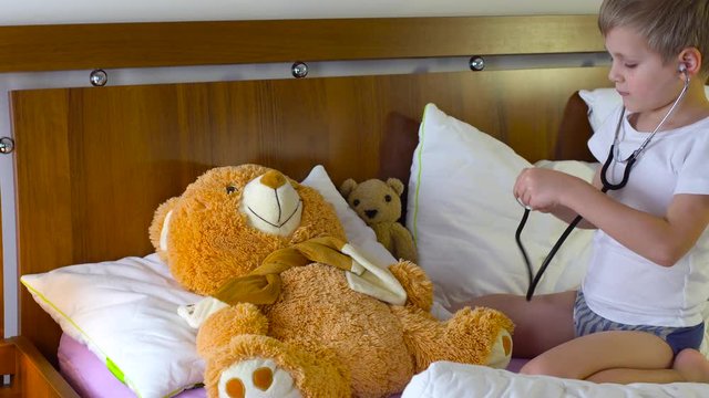 cute boy playing doctar with taddy bear
