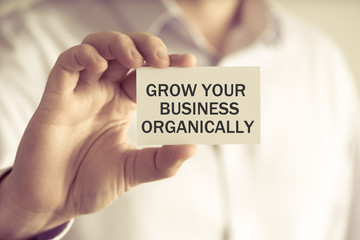 Businessman holding GROW YOUR BUSINESS ORGANICALLY message card