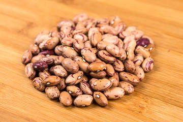 Organic cranberry beans isolated on a wood background