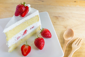 Closeup of strawberry cake with fresh strawberry on wooden background. Homemade strawberry cake.