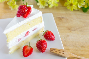 Closeup of strawberry cake with fresh strawberry on wooden background. Homemade strawberry cake.