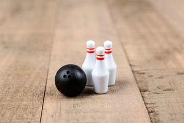 Toy bowling ball and pins isolated on a wood background
