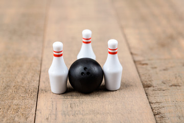 Toy bowling ball and pins isolated on a wood background