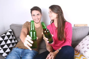 Couple drinking beer on couch.