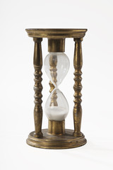 The old hourglass made of bronze on a white background. Close-up