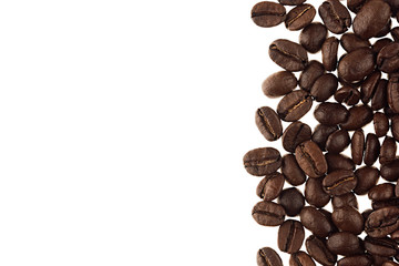 Heap roasted coffee beans as decorative border with copy space isolated on white background.