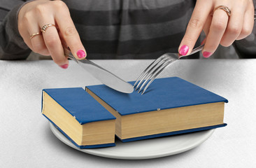 education creative concept, hands cut book on plate