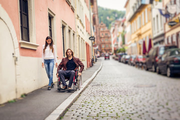 Young Couple In Wheelchair Strolling In The City