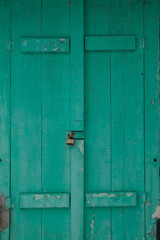 Old faded green shutters locked closeup grunge