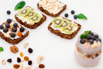 Muesli, nuts and berries. Breakfast preparation. Granola with fresh berries in jar on stone background, top view, banner. Healthy food and Clean Eating concept