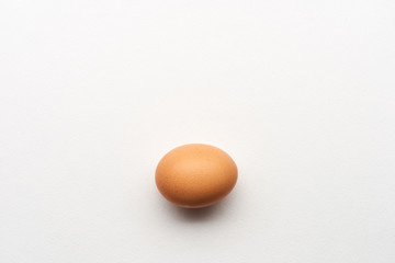 Single simple brown egg on white background