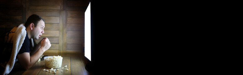 Naklejka premium man watching television at home on the floor