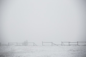 old fence on foggy winter day . winter countryside landscape