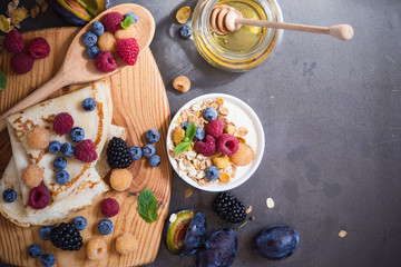 Healthy breakfast muesli and crepes with fresh berries and fruits