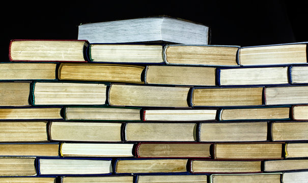 Big pile of books on dark background close up