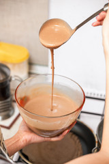 Laying process of liquid chocolate biscuit dough in a baking dish at the kitchen